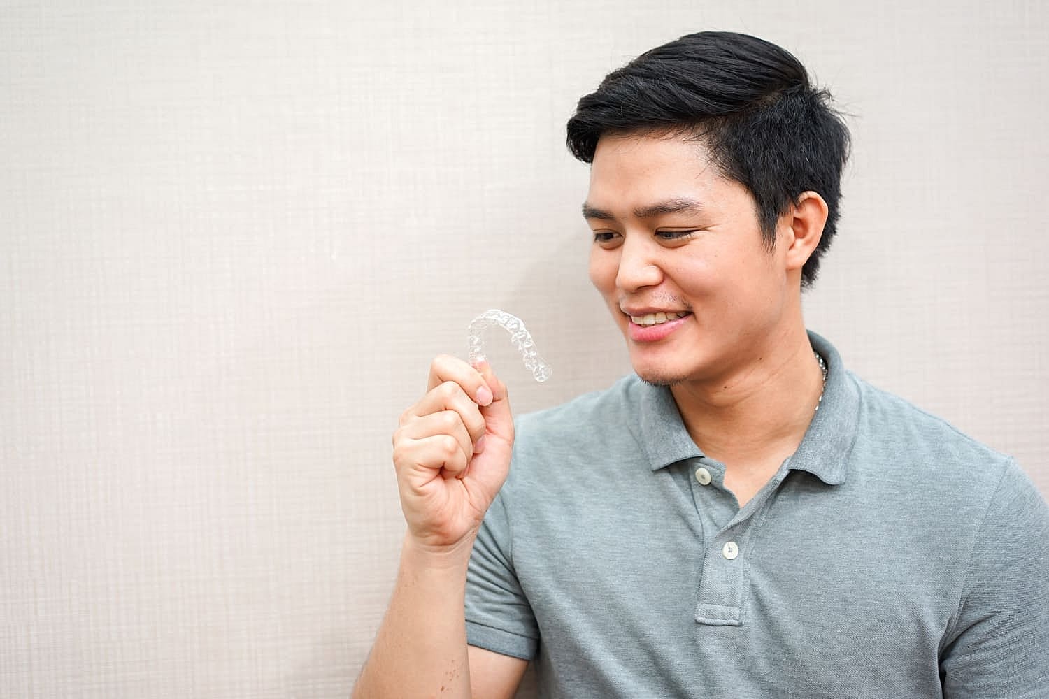A man is holding Invisalign at Fiesta Orthodontics in San Antonio, TX.