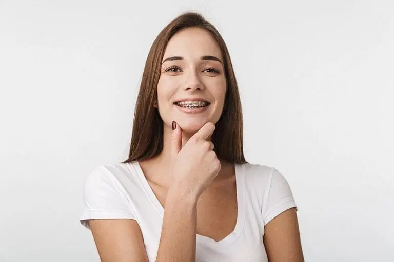 attractive young woman standing isolated metal braces - Overbite vs Underbite in San Antonio, TX.