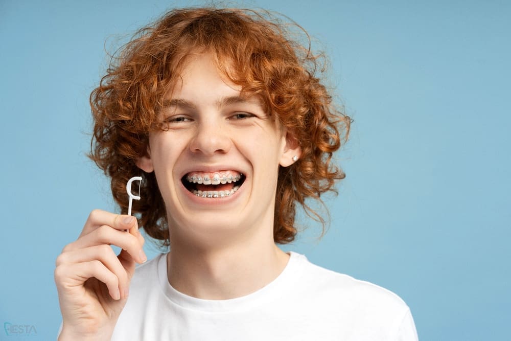 curly red haired ginger woman with snow white smile metal braces on teeth - How to Get Braces Glue Off Teeth in San Antonio, TX
